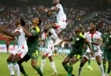 Des footballeurs suivent un ballon aérien pendant une rencontre